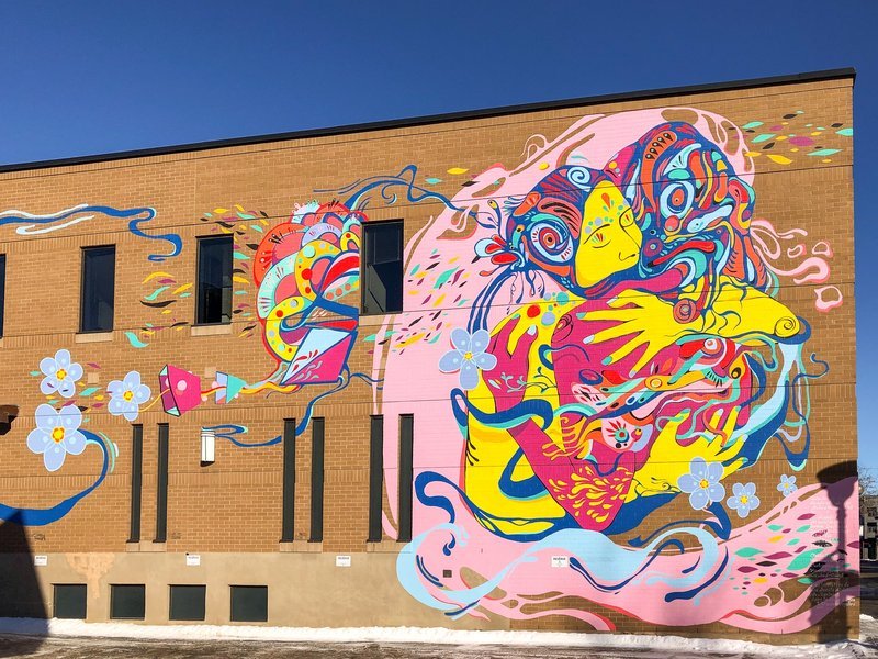 Une fresque murale colorée à Griffintown, Montréal, reflétant l'art urbain vibrant de la ville. Fresque murale à Griffintown, Montréal