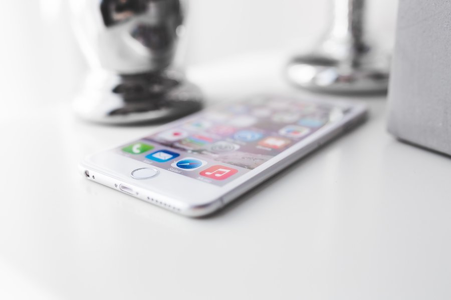 iPhone affichant des applications sur un bureau blanc